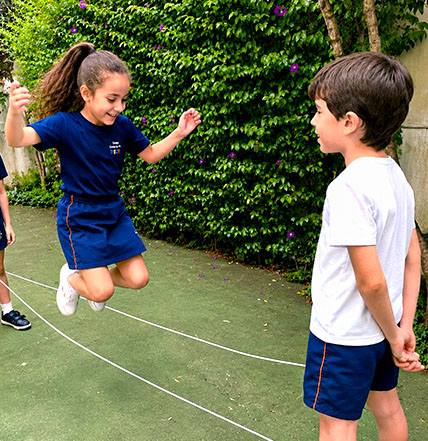 Alunos brincam de pular corda na área externa