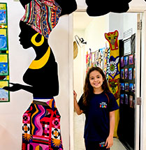 Aluna posa ao lado de mural artístico
