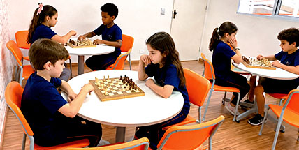 Alunos jogam xadrez na sala de aula
