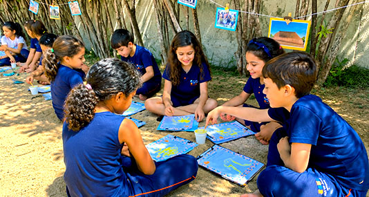 Alunos leem em atividade ao ar livre